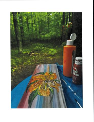 painted wood board with flower and red paint bottle